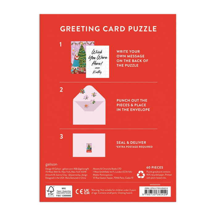 Back of Joanna Clayβs Meowy Christmas Greeting Card Puzzle box shows three steps: write a message, punch out 60 puzzle pieces, and mail. Features cat-themed art, sample card, envelope images, and festive red packaging.