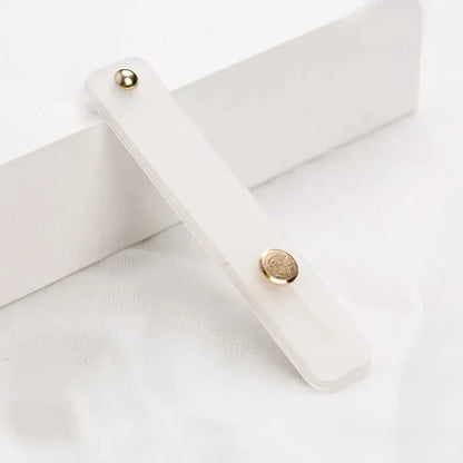 A white wooden box with a gold button