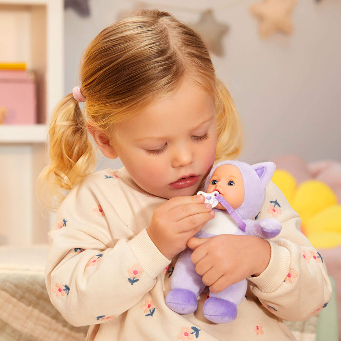 Young girl playing with the purple cat doll in a cozy room.