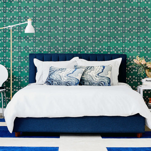 Block Print Floral WALLPAPER in green displayed in a bedroom.