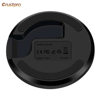 A close up of a black robot vacuum cleaner on a white background