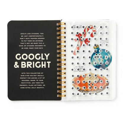 The Googly & Bright Holiday Sticker Book by Brass Monkey features spiral-bound pages with festive stickers—like candy canes, ornaments, and big holiday treats—all accented with playful googly eyes for extra cheer.