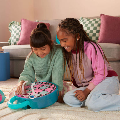 Two young girls opening the Ultimate Eye Spy Surprise  toy on the floor.