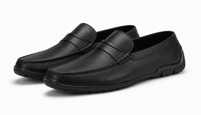 Pair of black leather loafers on a white background