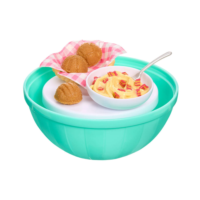 Green bowl with a white interior containing bread and a small bowl of pasta on a white background
