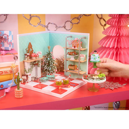 Miniature Christmas scene with a hand holding a small cake stand.