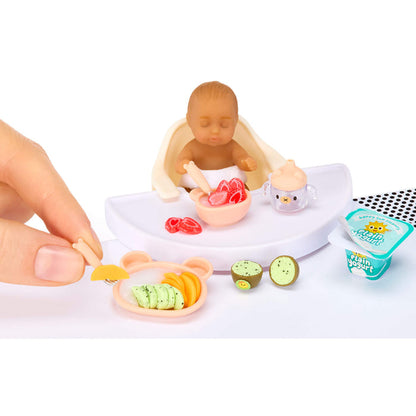 Playset with a mini baby figurine, food items, and a container labeled 'Plain Yogurt' on a white background.