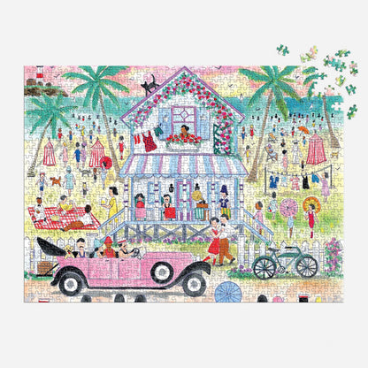The Michael Storrings Roaring 20s Beach House 1000 Piece Puzzle by Michael Storrings features a vibrant beach scene with people, palm trees, a stilted seaside house, and a vintage pink car. Some puzzle pieces remain unplaced in the top right corner.