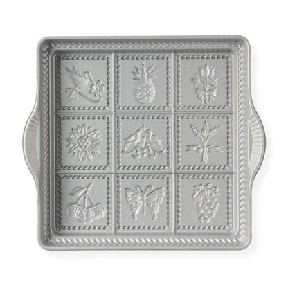 Decorative metal tray with embossed designs on a white background