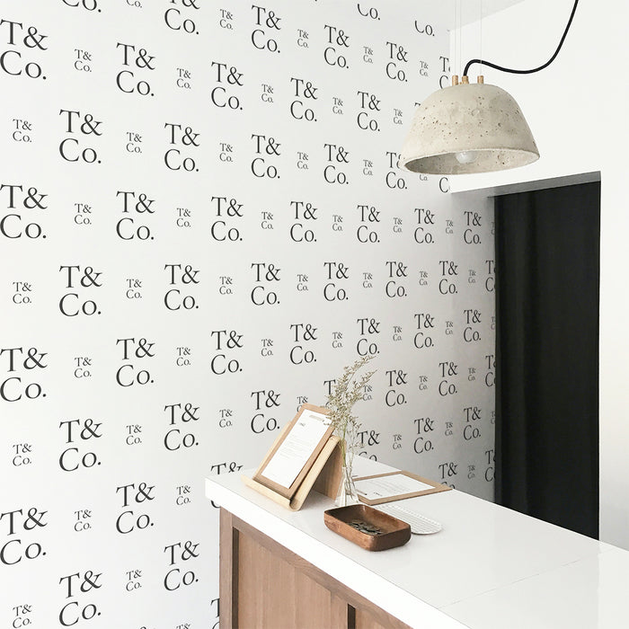 A wall in a business featuring a step-and-repeat wallpaper print created by Tempaper, showcasing the company's logo.