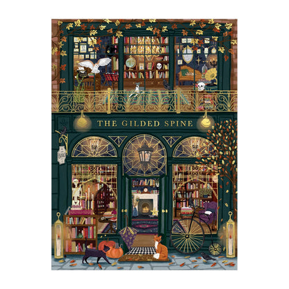 Experience Sally Wilson’s The Gilded Spine 1000 Piece Foil Puzzle, featuring a whimsical bookstore with two book-filled floors, arched windows, golden accents, fall leaves, and cozy autumn vibes—plus charming cats outside.