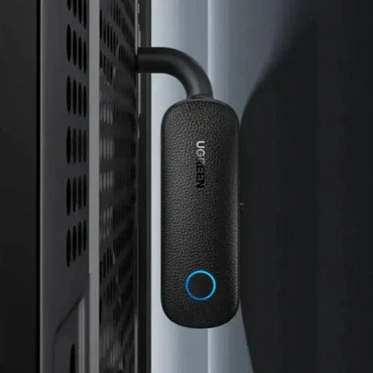 A close up of a black device with a blue button