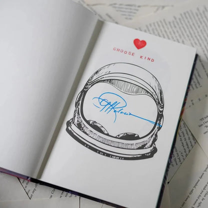 Wonder Annotated Special Edition signed page by R.J. Palacio — open book showing a black-and-white astronaut helmet illustration with a red heart and 'CHOOSE KIND' text, signed in blue ink by R.J. Palacio across the visor